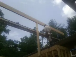Carpenter setting a ridge beam over a new addition frame — Ice Dam Removal by Roofing Brothers in Blackstock