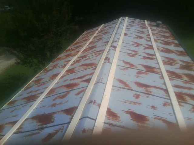Rusted metal roof panels with new wood purlins before replacement — Storm Damage Roof Repair in Blackstock by Roofing Brothers