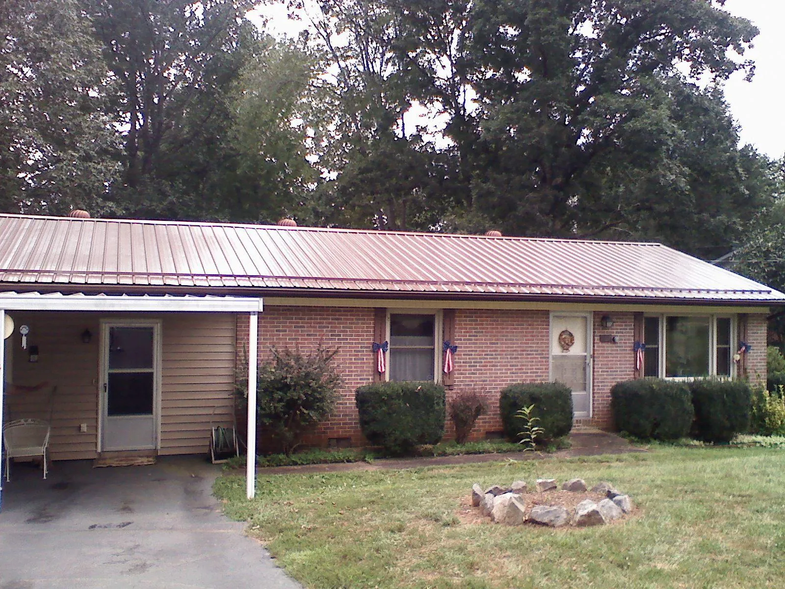 Bronze metal roof and carport on a brick ranch home — Roof Repair work by our crew in Blackstock